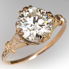 an old mine cut diamond ring with two tone gold band and filigree accents