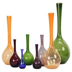 five different colored vases are lined up in a row on a white background,