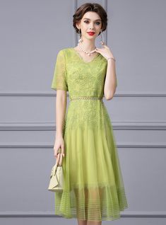 Joyous occasions call for a dress as delightful as this mother of the bride ensemble! Embrace the festivities in this light green dress that mirrors the freshness of a new beginning. Embellished with refined lace patterns and accented with a tastefully bejeweled waistline, this dress is a true work of art. The V-neck and short sleeves add a touch of modern sophistication, while the floaty skirt ensures you'll move with ease and confidence. Perfect for daytime ceremonies or evening receptions, this dress shines with a subtle sheen, promising to keep you in the spotlight without stealing the show. It's the ideal choice for the mother who stands proudly by her child, her attire a reflection of the love and pride that fills her heart. Green Lace Dress For Formal Occasions, Elegant Embellished Pista Green Dress, Formal Green Lace Dress, Spring Lace Dress For Mother Of The Bride, Spring Mother Of The Bride Lace Dress, Green Lace Dress For Formal Events, Green Short Sleeve Lace Dress For Party, Elegant Fitted Pista Green Dresses, Elegant Green Lace Dress