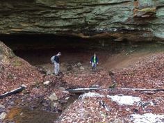 two people standing in the middle of a cave