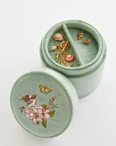 two green velvet jewelry boxes with designs on them