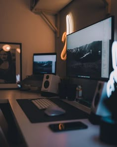 two computer monitors sitting on top of a desk