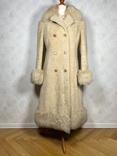 A beautiful double-breasted coat made of sheep fur, finished with real soft fur on the collar, cuffs and at the bottom. An incredibly rare item from the 1970s. The flathead is in almost perfect condition, with normal traces of use. There are no ugly spots and it is well preserved. You won't get cold in this coat and you will definitely be noticed, the interesting texture of the fur attracts attention with its slight shine - pearl color. I highly recommend it. A truly stylish thing. Dimensions: sleeve from the collar: 73 cm armpit sleeve:43  cm in the bust: 2x 46 cm waist: 2x 42 cm in the hips: 2x  47cm total length: 104 cm Cream Sheepskin Fur Coat For Winter, Cream Sheepskin Fur Coat With Faux Fur Trim, Fitted Cream Faux Fur Coat, Vintage Long-sleeved Faux Fur Coat, Vintage Winter Fur Coat With Faux Fur Lining, Vintage Long Sleeve Fur Coat With Faux Fur Lining, Vintage Long Coat In Faux Fur, Vintage Faux Fur Lined Outerwear, Cream Long Fur Coat With Faux Fur Lining