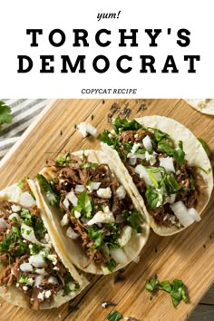 three tacos with meat, onions and cilantro on a wooden cutting board