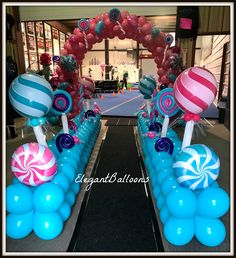 an entrance decorated with blue, pink and white balloons for a candy land birthday party