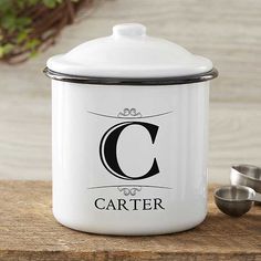 a white canister sitting on top of a wooden table next to measuring spoons