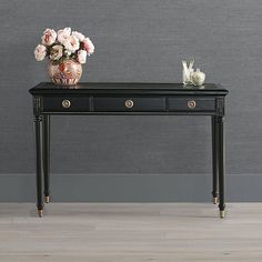 a black table with two drawers and flowers on top