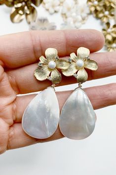 These statement bridal earrings will turn heads as you walk down the aisle. Featuring mother of pearl teardrop earrings with a gold flower stud base. Classic and modern wedding jewelry for brides, bridesmaids, and mother of brides. Wear these pearl teardrop wedding earrings for your rehearsal dinner, bridal shower, and your wedding for a touch of timeless elegance. Shop all your bridal jewelry needs at shopkateandmari.com. Chic Teardrop Pearl Earrings For Party, Party Pearl Drop Earrings Made Of Mother Of Pearl, Chic Silver Teardrop Pearl Earrings, Party Pearl Drop Earrings In Mother Of Pearl, Glamorous Teardrop Pearl Earrings, Glamorous Teardrop Pearl Earrings For Pierced Ears, Teardrop Pearl Earrings For Party, Party Teardrop Earrings With Pearl Drop, Chic White Teardrop Pearl Earrings