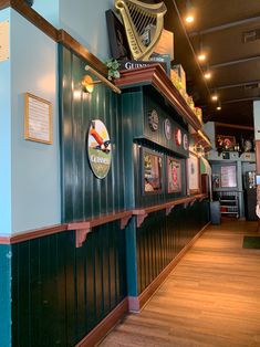 the inside of a restaurant with green and blue walls, wood flooring and harps on the wall