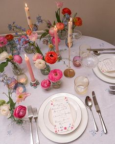 the table is set with flowers and candles