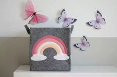 some butterflies are flying around a bag with a rainbow on it and another one has a pink butterfly