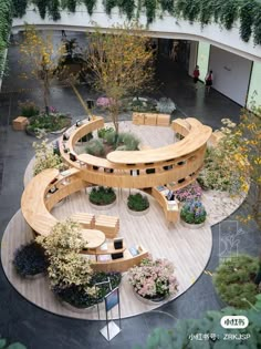 a circular wooden bench sitting in the middle of a garden filled with lots of plants