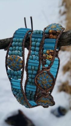 bracelets are hanging from a tree branch in the snow