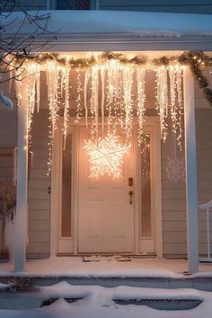 the front door is decorated with lights and snow