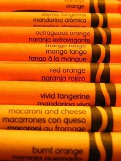 orange crayons are lined up in rows with black writing on the top and bottom