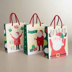 three christmas shopping bags with santa clause on them