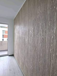 an empty room with wood paneling on the wall and sliding glass doors leading outside