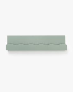 a light green shelf with wavy lines on it