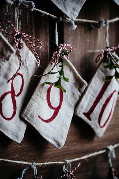 three linen tags with red numbers hanging on a string and twine, tied together