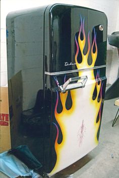 a black refrigerator with flames painted on it