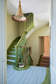 a green staircase leading up to the second floor in an old house with white painted floors