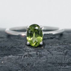 This ring is made from beautiful soft green Peridot which has beautiful sparkling lemony mint green hues. It is size 5.5. The rectangular faceted gemstone is 5 mm mm x 7 mm and is prong set in sterling silver.  Your sterling silver ring will be shipped gift boxed with a jewelry card listing gemstones and metal used. Green Peridot Birthstone Ring For May, Classic Peridot Green Rings, Classic Green Peridot Ring, Green Peridot Solitaire Birthstone Ring, Green Faceted Ring For Anniversary, Imperial Topaz, Green Hues, Jewelry Card, Green Peridot