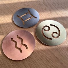 three circular metal signs sitting on top of a wooden table