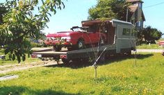 an old red truck is parked in the grass