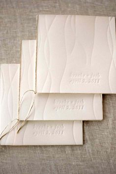 three white wedding cards with string tied to the front and back, on top of each other