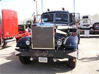 an antique truck parked in a parking lot next to other trucks and people looking at it