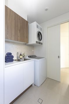 a washer and dryer in a small room next to a kitchen counter top