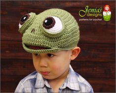 a young boy wearing a crocheted frog hat