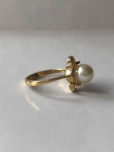 June Pearl is a vintage ring. Crafted in the mid-century in 14K yellow gold. The pearl is a natural, lustrous 6.8 millimeter round pearl. This simple ring will make a wonderful staple jewelry piece for someone who appreciates pearls or has a June birthday or anniversary month. The ring is very comfortable on the hand and tapers from 1mm to 2.18mm at the bottom of the shank. Currently a size 5.5 (Can be sized up or down upon request) Every Antique piece of jewelry we sell at Heirloom Pavé has bee Classic Open Opal Ring, Timeless Oval Pearl Ring For Wedding, Classic Pearl Ring With Gemstone For Anniversary, Adjustable Oval Pearl Ring For Wedding, Vintage Gold Hallmarked Pearl Ring, Vintage Oval Flower Ring For Formal Occasions, Vintage Style Oval Flower Ring For Formal Occasions, Antique Hallmarked Pearl Ring For Wedding, Yellow Gold Pearl Ring For Anniversary