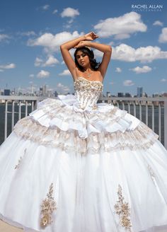 a woman in a white wedding dress posing for the camera with her hands on her head