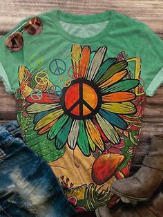 a green shirt with a flower and peace sign on it, next to cowboy boots