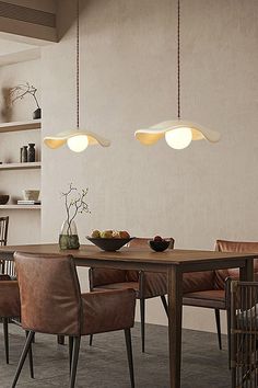 a dining room table and chairs with lights hanging from the ceiling