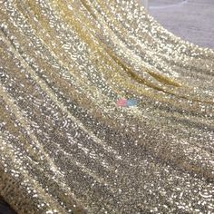 gold sequin fabric with white dots on the top and bottom, as well as an image