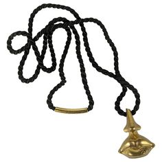 an ancient egyptian gold head pendant on a black rope necklace with a golden hook clasp