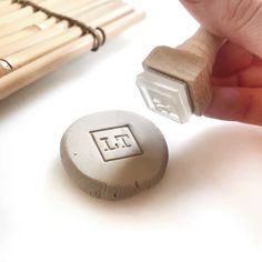 someone is stamping the letter t on a wooden stamper next to some bamboo sticks