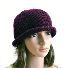 "Man's or woman's rolled brim hat, hand knit in deep purple, dark and deep like an eggplant. This retro knit hat is deceptively simple, and very flattering for almost any face shape or complexion. Wear it in fall, winter or spring. This dramatic shade will make a dynamic accent for many seasonal styles. The hat is knit from a lusciously soft acrylic yarn, perfect for people with sensitivity to animal fibers. It is sized to fit an average adult head, about 21-22\" circumference, with a little bit of stretch to fit your hair without flattening it. The length can be adjusted by rolling the brim up or down.  This hat is ready to to be shipped within 24-48 hours after receiving your order. Fiber care: hand wash and dry flat (roll gently in a towel first to squeeze out the excess water) to prese Adjustable Knitted Beanie With Short Brim, Knitted Adjustable Beanie With Short Brim, One-size Knitted Brimmed Hat, One Size Knitted Brimmed Mini Hat, Brimmed Beanie One Size, Adjustable Brimmed Hand Knitted Beanie, Hand Knitted Adjustable Brimmed Beanie, Knitted Brimmed Cloche Hat One Size, One Size Knitted Brimmed Cloche Hat