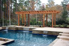 an outdoor swimming pool with steps leading up to it and a pergolated gazebo in the background