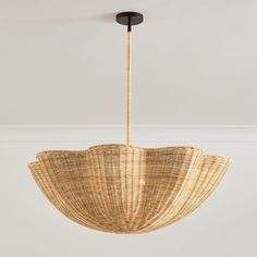 a wicker light fixture hanging from the ceiling in a room with white walls and flooring