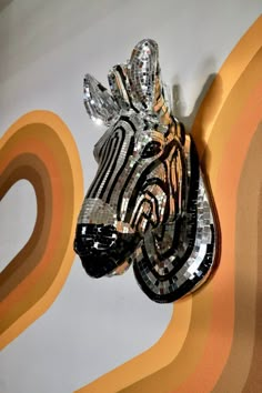 a zebra head made out of glass on a wall with an orange and yellow background