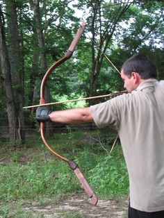 a man with a bow and arrow in the woods