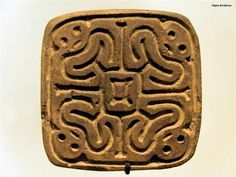 an intricately carved square object in the shape of a rectangle with two snakes on it