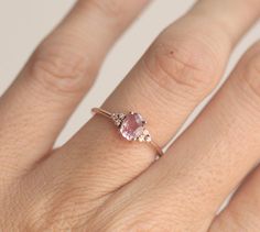 a woman's hand with a pink diamond ring on top of her left hand