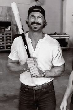 a man holding a baseball bat and smiling