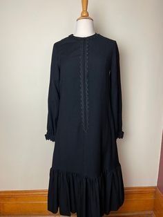 "Vintage 1960s Marimekko classic black wool maxi dress, possibly a Liisa Suvanto. Classic 1960s Marimekko wool dress. Long sleeves, front-zip closure with buttons on cuffs, lace detailing around neckline, down front and on cuffs. Large ruffle detail on bottom. Ankle length. I think this might be a Liisa Suavnto dress, and it is from the early 60s. The last pic shows some examples of one color, wool, Liisa Suvanto Marimekko dresses from the early-mid 60s. This a classic, Marimekko take on a littl Modest Black Maxi Dress For Formal Occasions, Black Wool Evening Dress, Black Wool Dress For Evening, Black Wool Dress For Formal Occasions, Black Vintage Maxi Dress With Long Sleeves, Black Vintage Long Sleeve Maxi Dress, Vintage Formal Maxi Dress For Fall, Formal Vintage Maxi Dress For Fall, Black Wool Dress For Fall