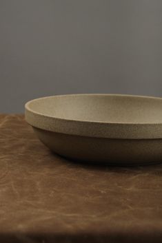 a white bowl sitting on top of a brown table