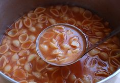 a pot filled with pasta and sauce on top of a stove